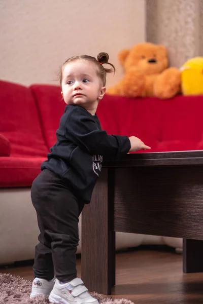 Genç bebek kız siyahlı yürümeyi öğrenmek — Stok fotoğraf