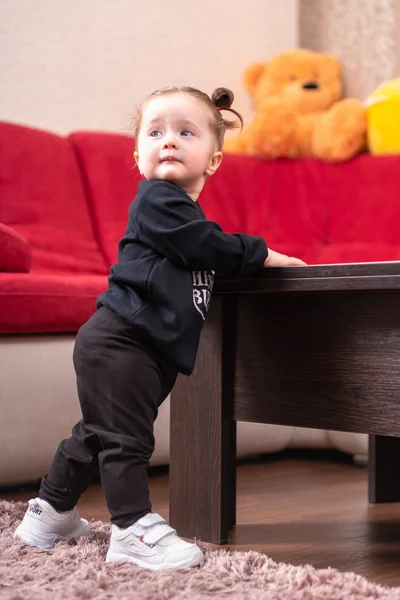 Söt liten flicka som stödja sig på ett bord — Stockfoto