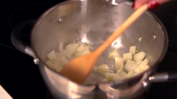 Kvinna matlagning tärnad lök och potatis — Stockvideo