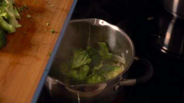 Cook het toevoegen van verse roosjes van broccoli — Stockvideo