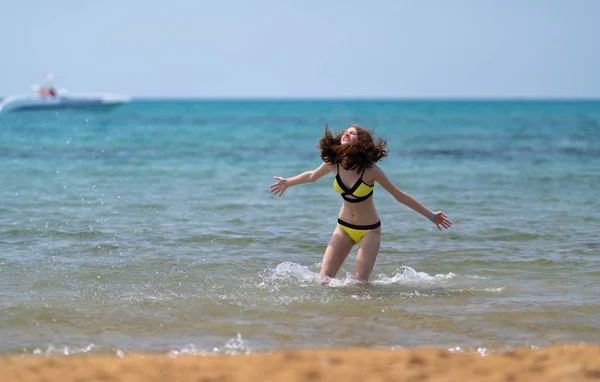 Jovencita alegre salpicando en el mar — Foto de Stock