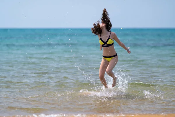 Carefree young woman frolicking in the surf — Stock Photo, Image