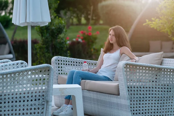 Mujer joven delgada relajándose al aire libre en un sofá — Foto de Stock