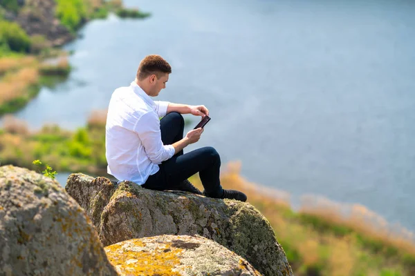 Молодой человек проверяет свой мобильный на наличие сообщений — стоковое фото