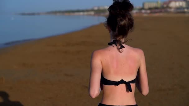 Vista trasera de una joven quemada por el sol corriendo — Vídeo de stock