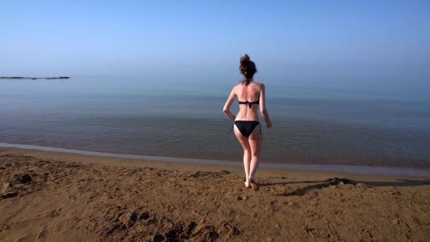 Menina queimada pelo sol correndo através de uma praia de areia — Vídeo de Stock