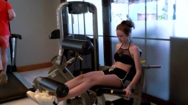 Spor salonunda karın çatırdatma makinesi kullanan genç bir kız.
