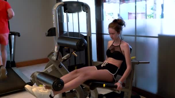 Giovane ragazza che utilizza la macchina addominale crunch in una palestra — Video Stock