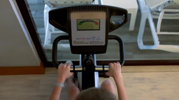 Vista aérea de la persona que usa bicicleta estática en el gimnasio — Vídeos de Stock