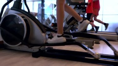 Spor salonunda ekipman üzerinde çalışan insanlar