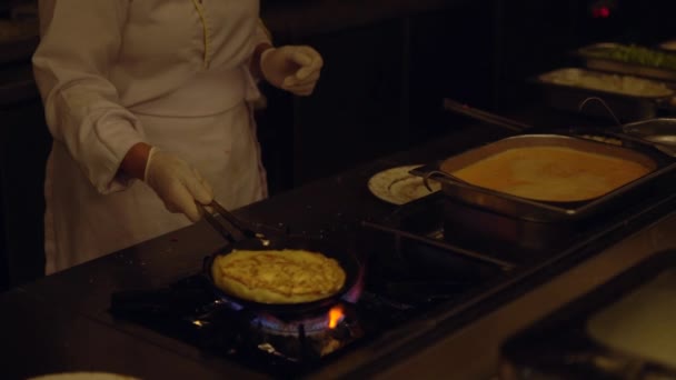 Chef preparando una tortilla de huevo sobre un quemador — Vídeo de stock