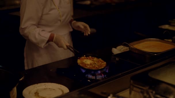 Chef cocinando una tortilla sobre una placa de gas — Vídeos de Stock