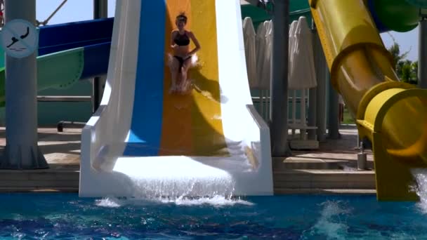 Young woman using a water slide at a resort — 图库视频影像