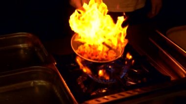 Yanan sıcak bir tavayı çeviren şefin yakın çekim