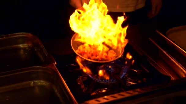 Κοντινό κομμάτι του σεφ που γυρίζει ένα φλεγόμενο τηγάνι — Αρχείο Βίντεο