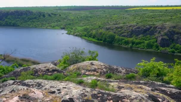 Zoom arrière d'un affleurement rocheux surplombant une vallée — Video