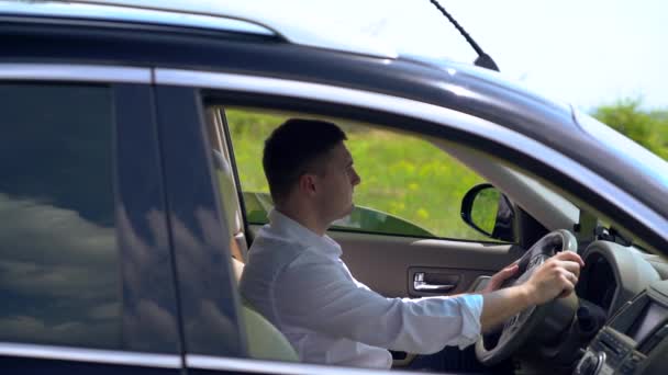 Jovem sentado atrás de um volante — Vídeo de Stock