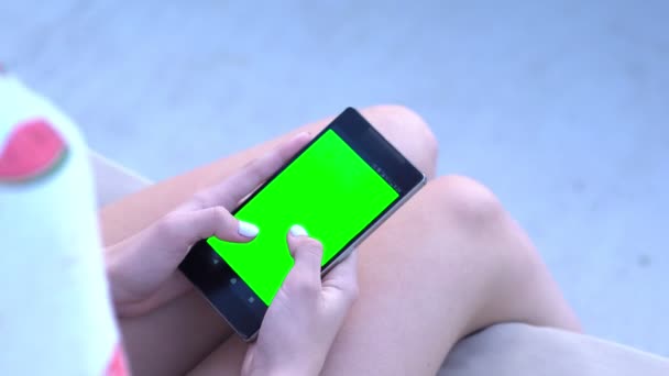 Junge Frau sitzt beim Scrollen auf ihrem Handy — Stockvideo