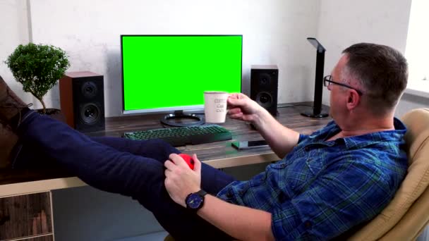 Man relaxing in the office with feet up on a desk — Stock Video