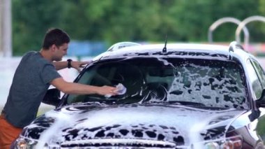 Genç adam camını sabunla yıkıyor.