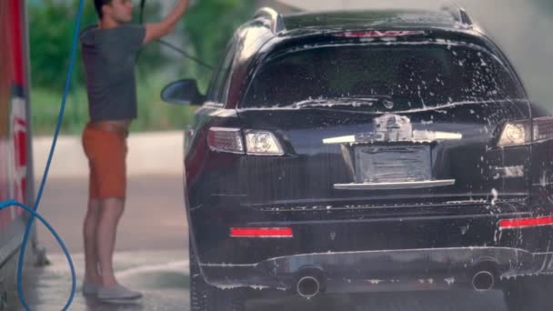 Jovem mangueira fora do telhado de seu carro — Vídeo de Stock