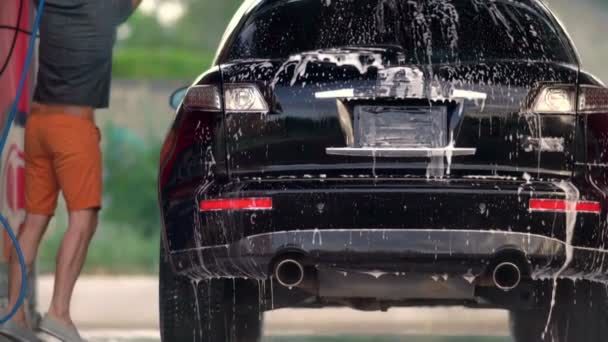 Baixo ângulo panning até o telhado de um carro a ser lavado — Vídeo de Stock