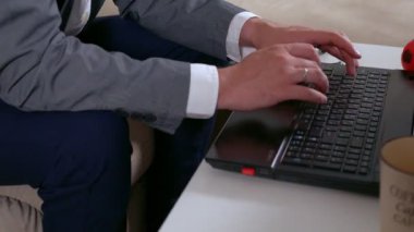 Dizüstü bilgisayarda yazan bir işadamının elleri