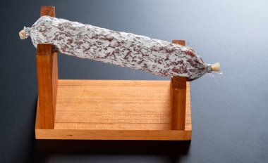 Bir ahşap standı üzerinde bütün baharatlı tedavi İtalyan salam