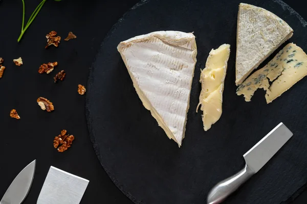 Выбор полумягких сыров на доске — стоковое фото