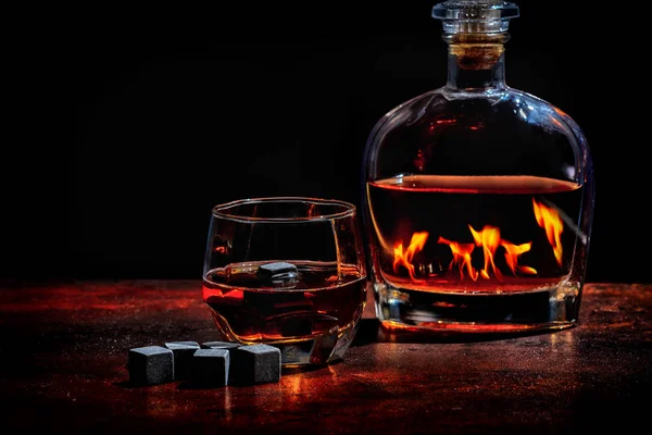 Bouteille de cognac ou whisky réfléchissant un feu — Photo