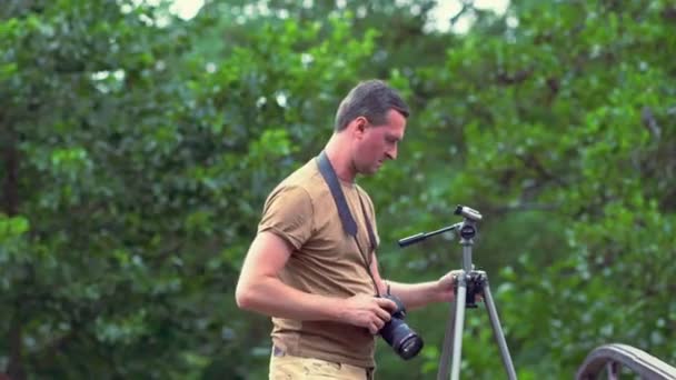 Fotograf ställa in sin kamera och stativ — Stockvideo