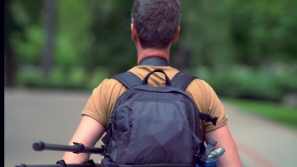 Homme portant l'équipement de caméra dans un sac — Video