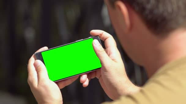 Mann blättert durch Informationen auf seinem Handy — Stockvideo
