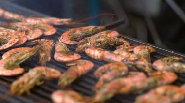 Bir ızgara üzerinde terbiyeli taze karides üzerinde yavaş tava