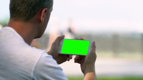 Άνθρωπος κρατώντας ένα οριζόντιο κινητό τηλέφωνο — Αρχείο Βίντεο