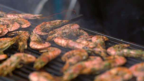 Gambas rosadas enteras chisporroteando en una parrilla — Vídeos de Stock