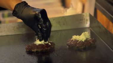 Şef ızgara üzerinde cheeseburger köftesi hazırlanıyor