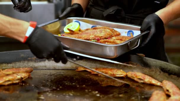Chef-kok het verwijderen van hele gegrilde vis uit een bakplaat — Stockvideo