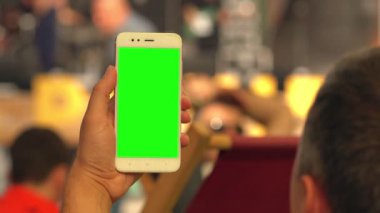 Bir etkinlikte boş bir cep telefonu tutan adam