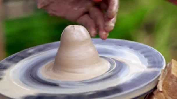 Поттер работает с влажной глиной на колесе — стоковое видео