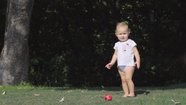 Urocza mała dziewczynka bawią się w ogrodzie — Wideo stockowe