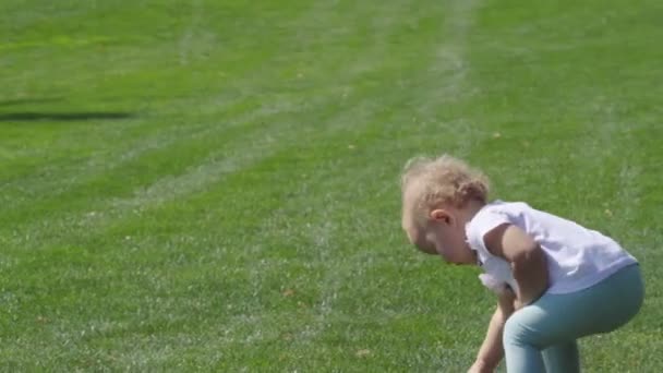 Niña rubia corriendo para atrapar una pelota — Vídeos de Stock