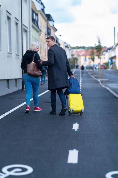 Casal andando pela rua com uma mala — Fotografia de Stock