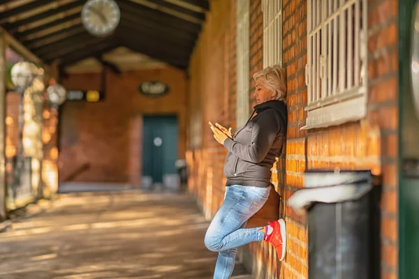 Mulher loira atraente mensagens de texto em seu celular — Fotografia de Stock