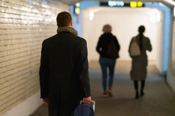 남자가 지하철을 지나가면서 여행 가방을 끄는 모습 — 스톡 사진