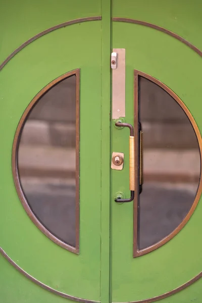 Colorful green door with circular glass windows — Stock Photo, Image