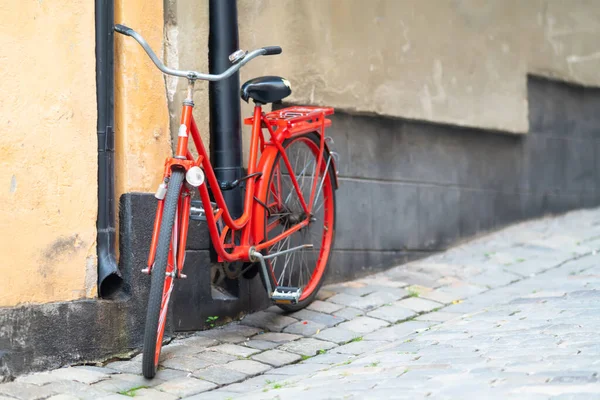 Vélo rouge vif stationné dans une rue urbaine — Photo