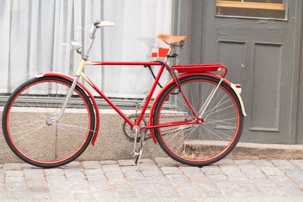 Цветной красный велосипед припаркован на улице — стоковое фото