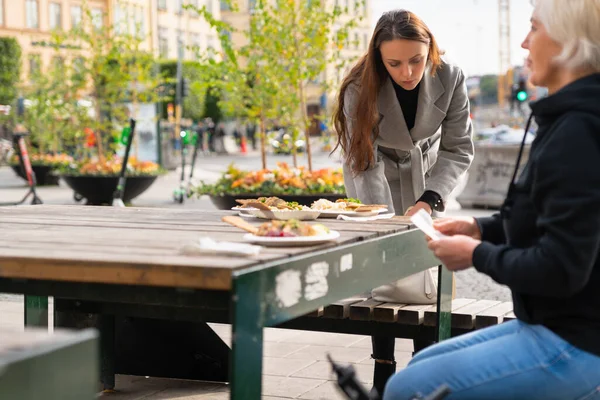 Dos mujeres sentadas para una comida al aire libre — Foto de Stock