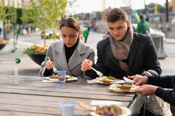 Jeune couple manger avec des amis ou de la famille — Photo